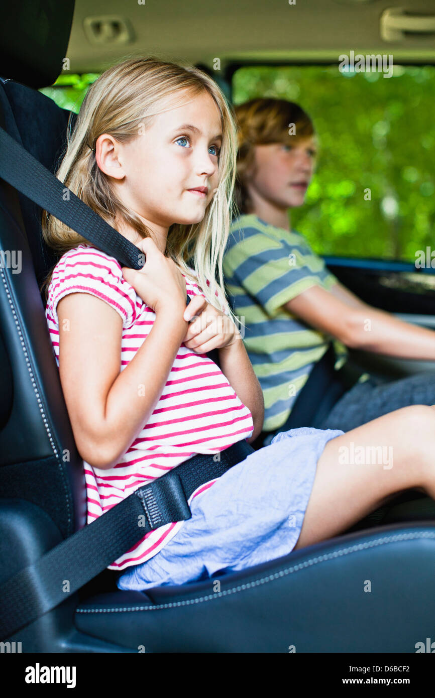 Girl sitting in car booster seat Stock Photo