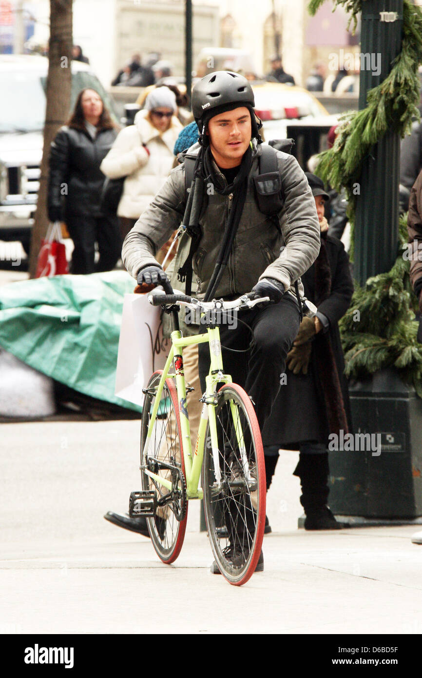 Zac Efron dressed as bike messenger on the set of his new film 'New Year's Eve' shooting in Manhattan New York City, USA - Stock Photo