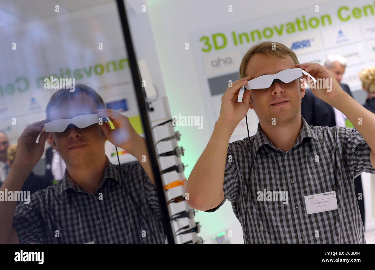 A visitor wears Zeiss 3D video glasses at the opening of the 3D ...