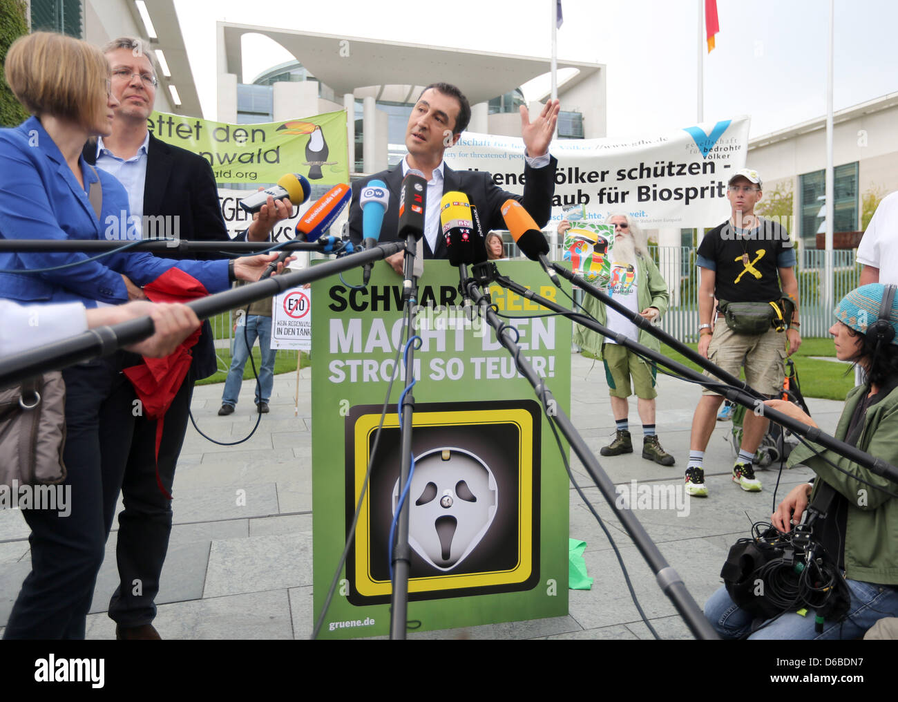 Chairman of the Greens Cem Ozedmir holds a sign asking the governing coalition to reduce energy prices before an energy summit with the government, employers and unions in Berlin, Germany, 28 August 2012. Topics of the summit include the developments concerning the costs of the energy turnaround. Photo: KAY NIETFELD Stock Photo