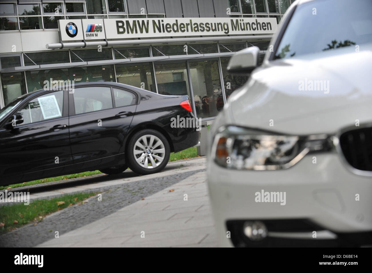 Two BMWs sit in front of a BMW dealership on the Frankfurter Ring in  Munich, Germany, 23 August 2012. Photo: Andreas Gebert Stock Photo - Alamy