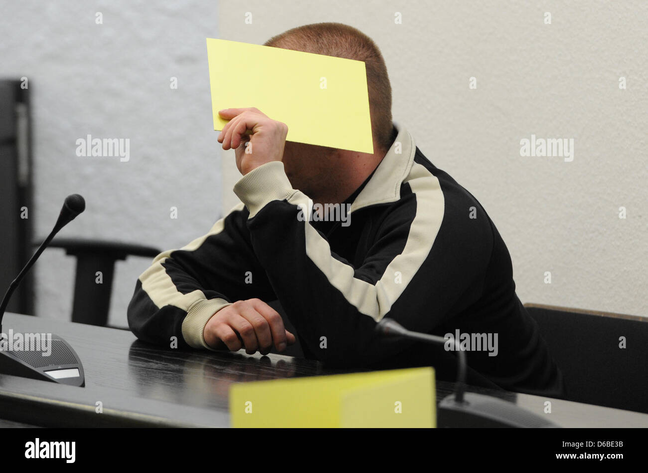 One of twelve accused sits in a court room of the district court in