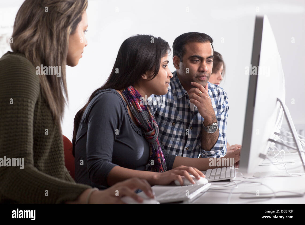 People using computers at desk Stock Photo - Alamy