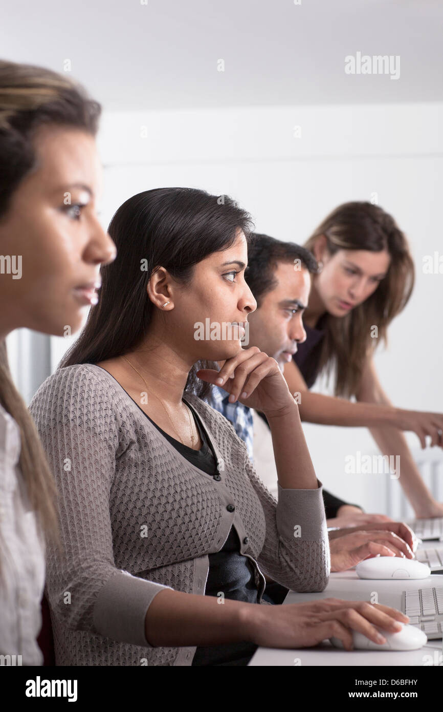 People using computers at desk Stock Photo - Alamy