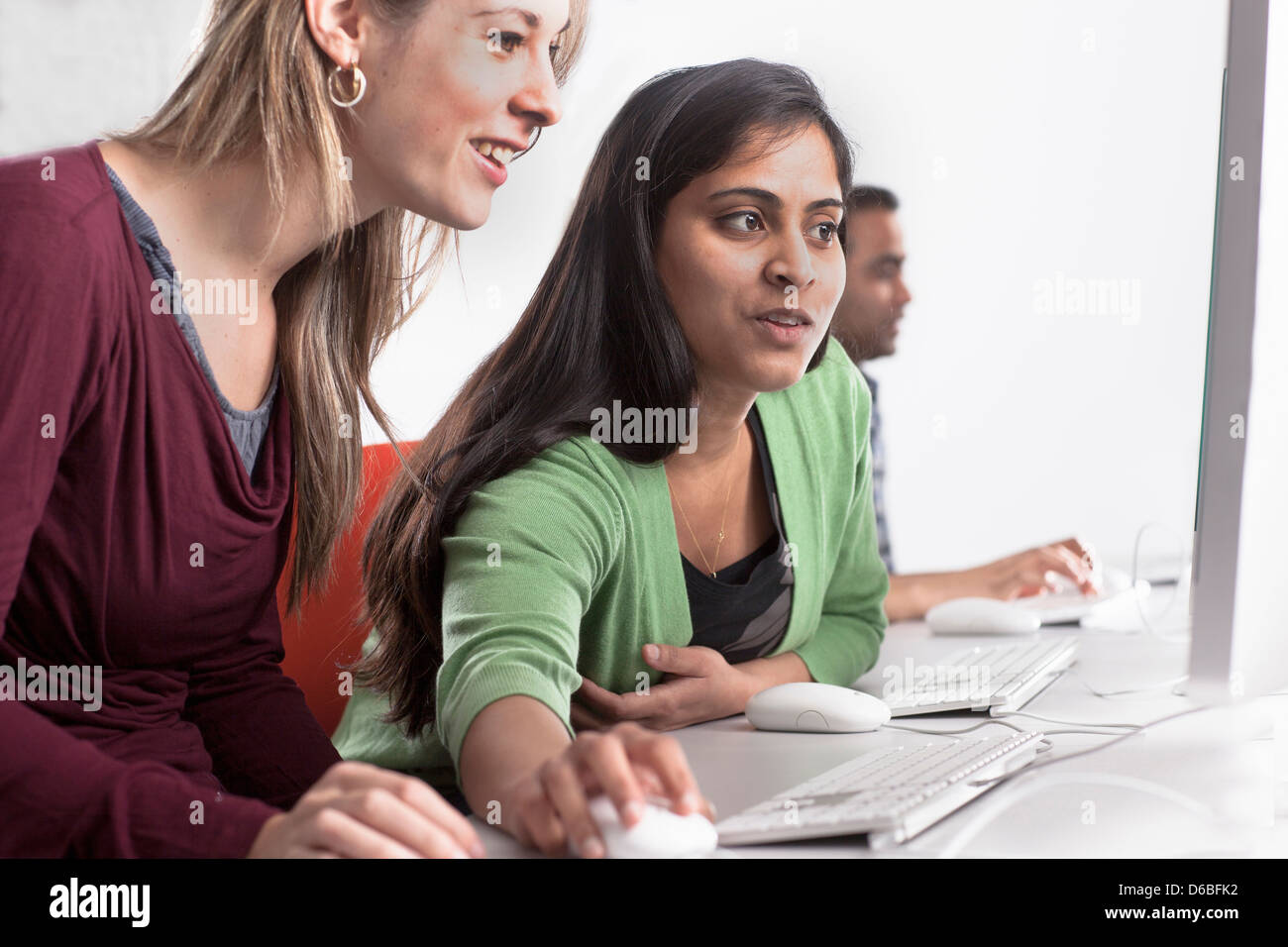 People using computers at desk Stock Photo - Alamy
