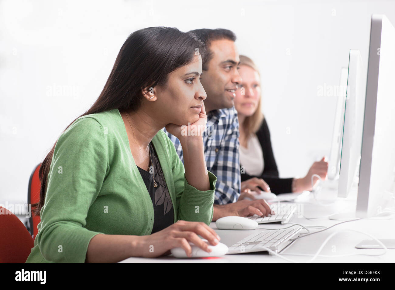 People using computers at desk Stock Photo - Alamy