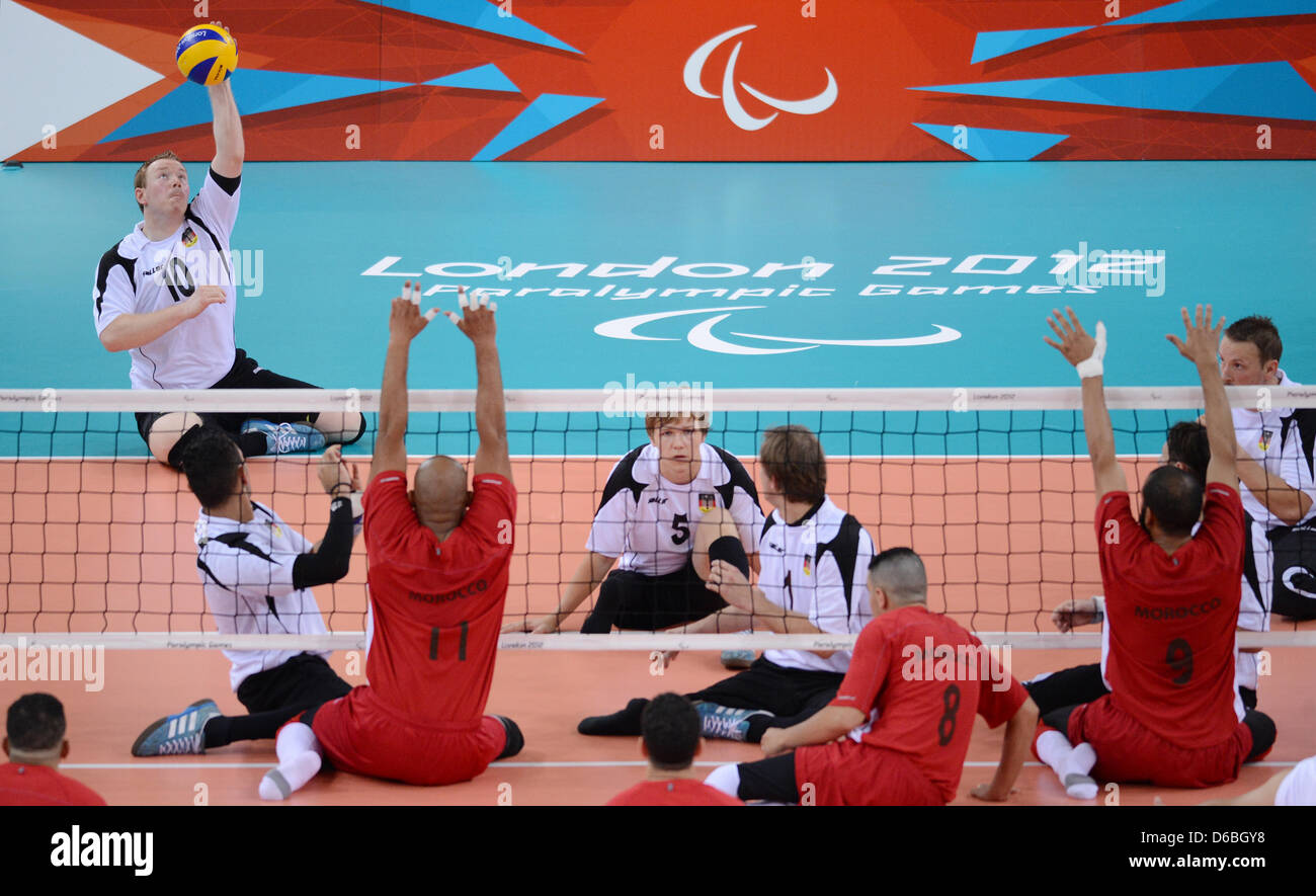 Christoph Herzog (L) of Germany hits the ball during the Preliminary Round Pool A match Germany vs Morocco of Men's Sitting Volleyball event in ExCel Centre during the London 2012 Paralympic Games, London, Great Britain, 31 August 2012. Photo: Julian Stratenschulte dpa  +++(c) dpa - Bildfunk+++ Stock Photo