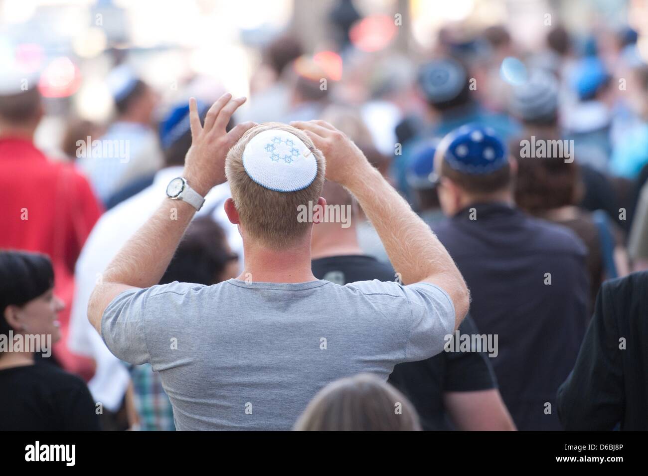 People walk along the streets wearing kippahs during a kippah flash mob in Berlin, Germany, 01 September 2012. The flash mob was initiated as a reaction to a recent brutal attack against a rabbi in the Berlin district Friedenau. Photo: SEBASTIAN KAHNERT Stock Photo