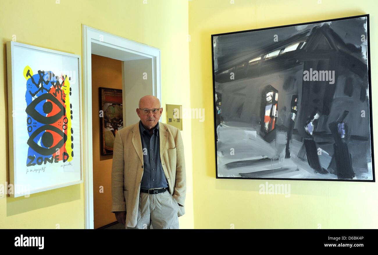 Professor of Physics Klaus Eberhard stands between the paintings 'For the Leipzig Hof' (1991) by A.R. Penck and 'Green Traffic Light' (1992, L-R) by Wolfram Ebersbach at his 'Gallery Hotel Leipzig Hof' in Leipzig, Germany, 23 August 2012. The buildings belong to the collection of around 450 pieces of art of Klaus Eberhard from Munich. They nake up the biggest private collection of  Stock Photo