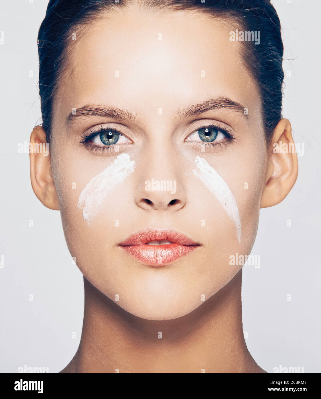 Woman with streaks of lotion on face Stock Photo