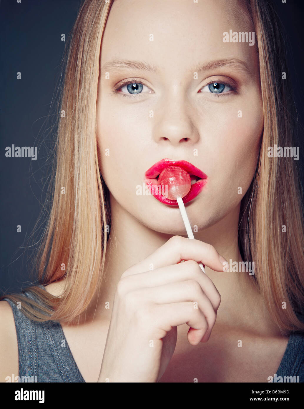 Smiling woman eating lollipop Stock Photo