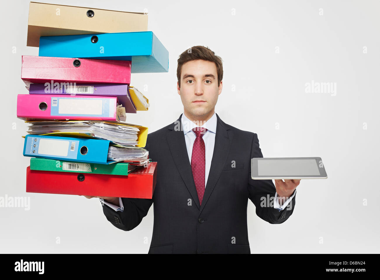 Businessman with stacks of folders and tablet computer Stock Photo