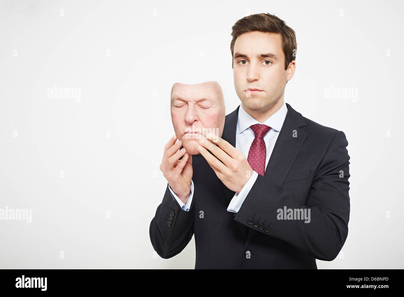 Businessman holding mask Stock Photo - Alamy