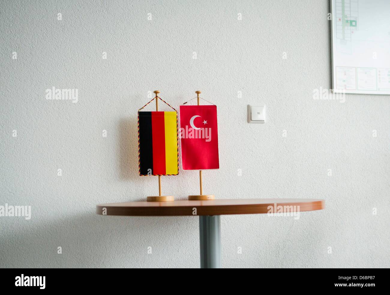A German and a Turkish flag stand in front of the offices of the Turkish newspaper in Mörfelden-Walldorf, Germany, 16 April 2013. 'Sabah' had laid a constitutional complaint against distribution of the journalist's spots. Photo: FRANK RUMPENHORST Stock Photo