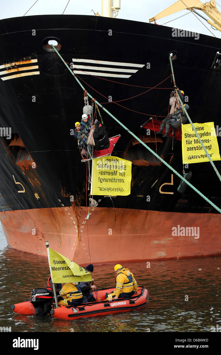 Activists of the environmental group Greenpeace hinders the fishing trawler 'Jan Maria' from departing from the fishing port in Bremerhaven, Germany, 02 January 2012. The activists blocked the propeller with a chain and some of them attached themselves to the strings of the ship. With this action Greenpeace protests against failing fishing policy and the exploitation of the seas. P Stock Photo