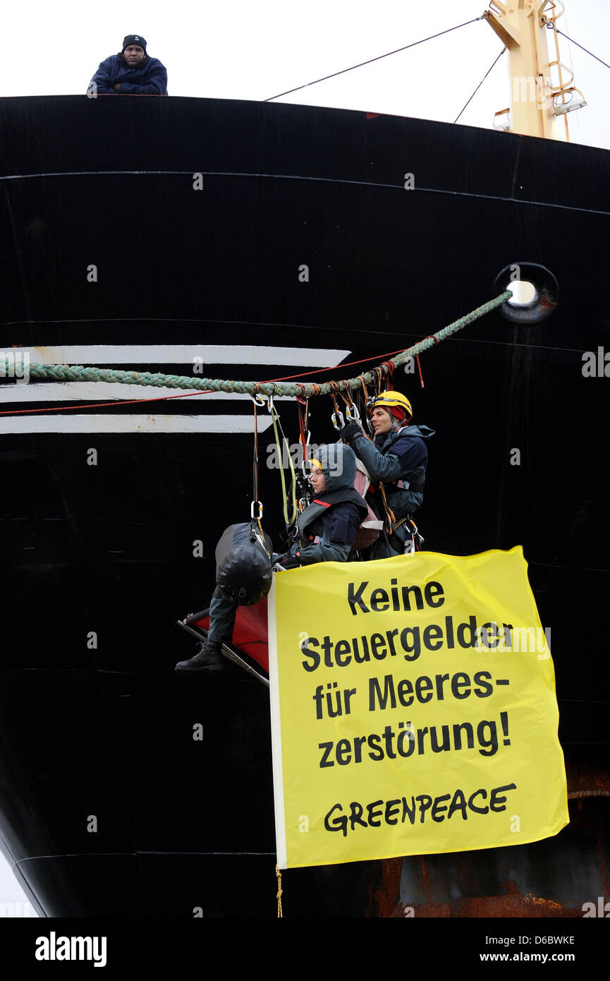 Activists of the environmental group Greenpeace hinders the fishing trawler 'Jan Maria' from departing from the fishing port in Bremerhaven, Germany, 02 January 2012. The activists blocked the propeller with a chain and some of them attached themselves to the strings of the ship. With this action Greenpeace protests against failing fishing policy and the exploitation of the seas. P Stock Photo