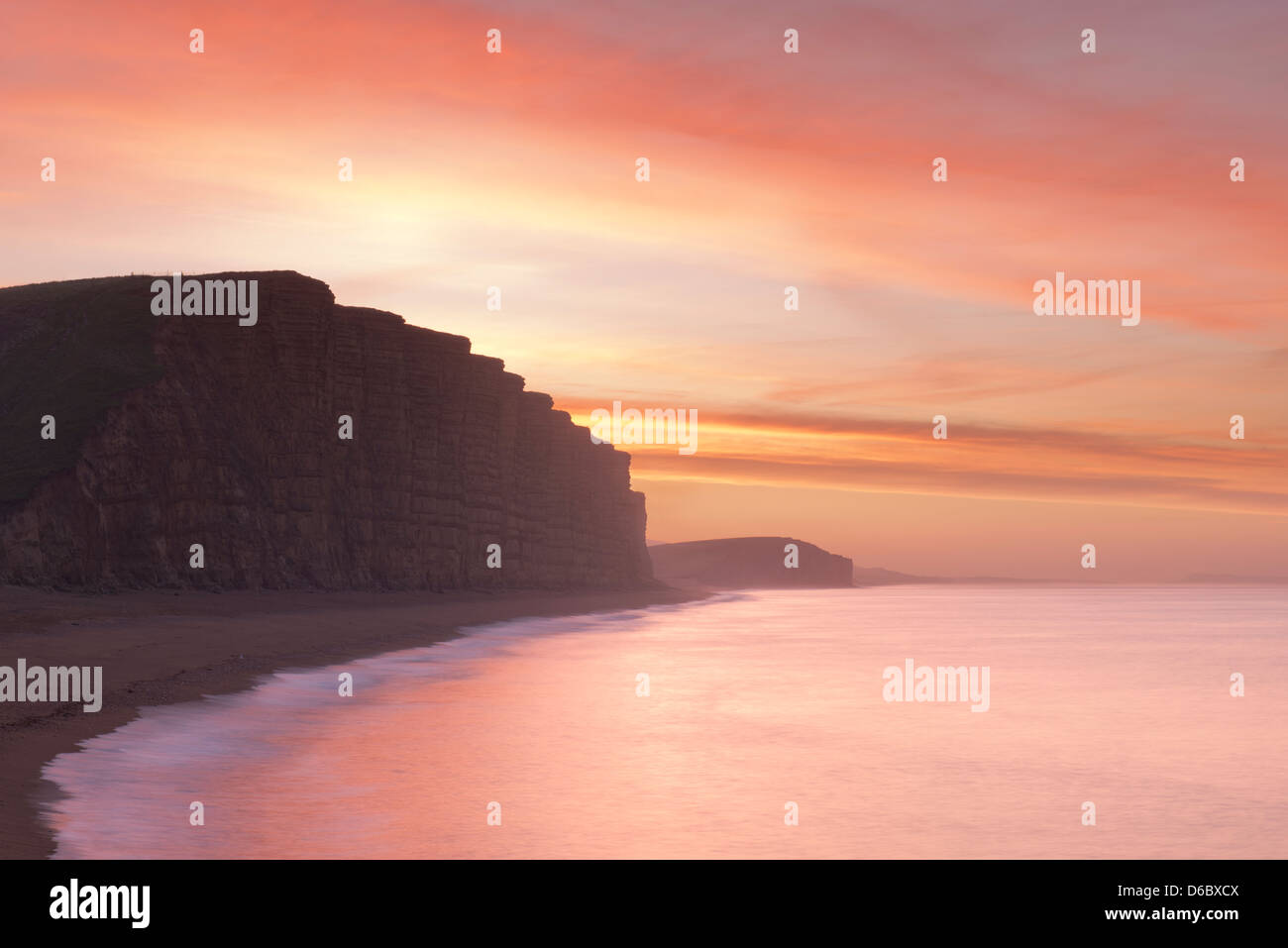 A stunning red sunrise in the sky above East Cliff at West Bay, Dorset, UK. Stock Photo