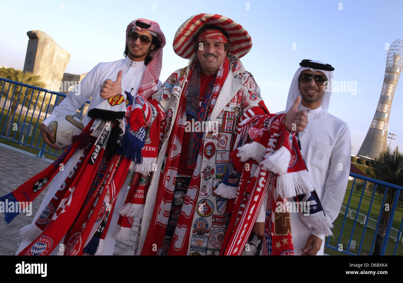 Two native fans and a Bavarian fan hold fan scarves and caps in Doha,  Qatar, 04 January 2012. From 02 January to 09 January 2012 the team of  Bayern Munich prepares for