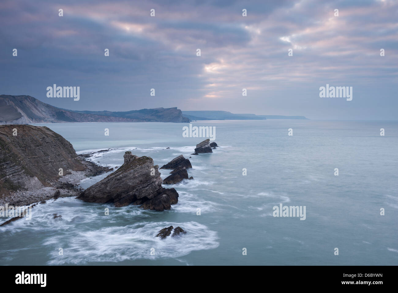 A dramatic sky at sunrise over Mupe Rocks and Worbarrow Bay on the Jurassic coastline, Dorset, UK. Stock Photo