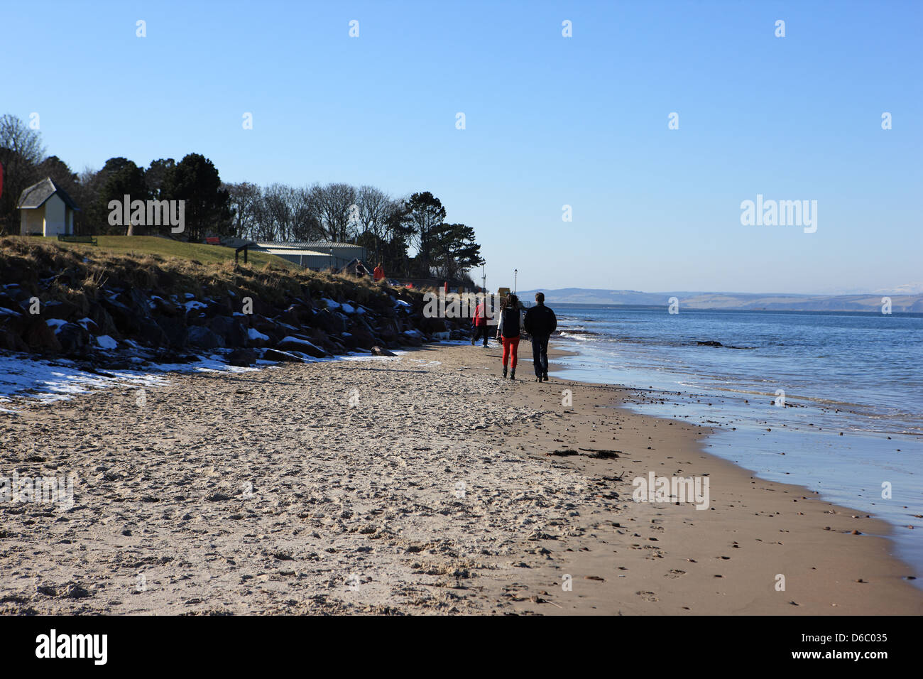 People walking on the beach at Nairn in the Scottish Highlands on a cold but sunny winters day Stock Photo
