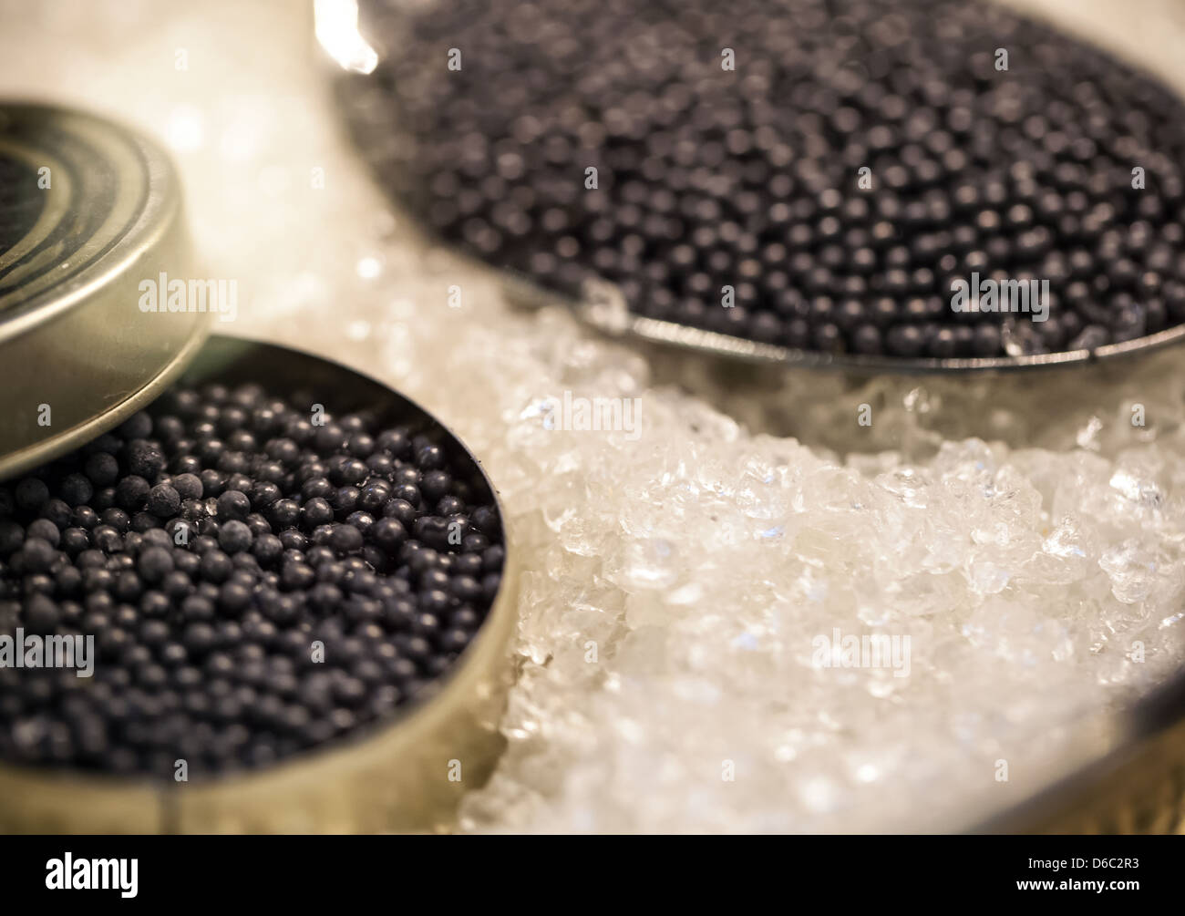 Macro with black caviar in small round metal tin and spoon on ice Stock Photo