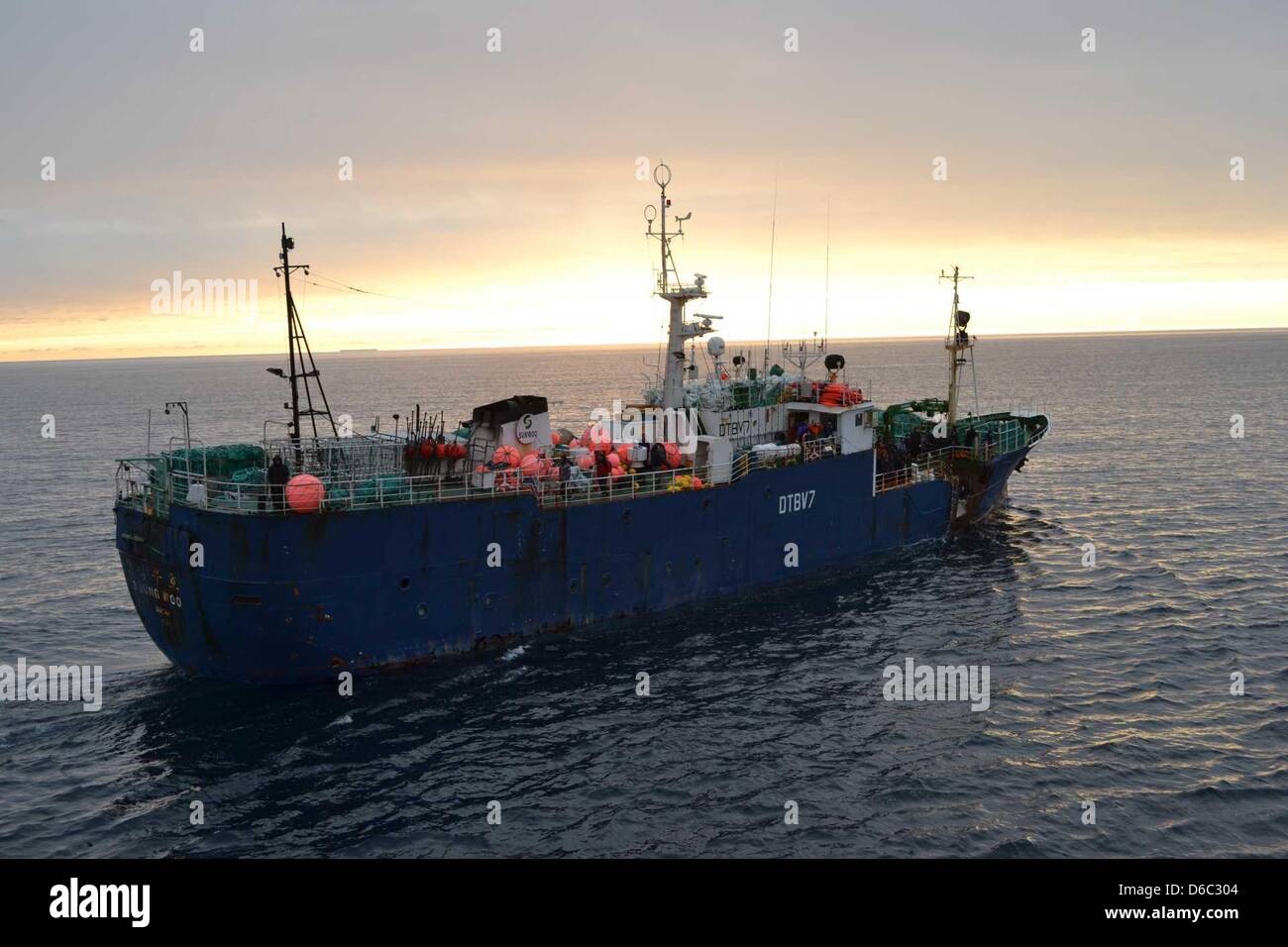 A sister ship takes on crew of the burning South Korean fishing trawler 'Jeong Woo 2' in the Antartic, 11 January 2012. A Russian fishing trawler collided with an iceberg before Christmas and now, a South Korean trawler has caught fire. 37 people were rescued by two nearby ships, but three of the crew are probably dead after the ship burned for hours before sinking, according to th Stock Photo