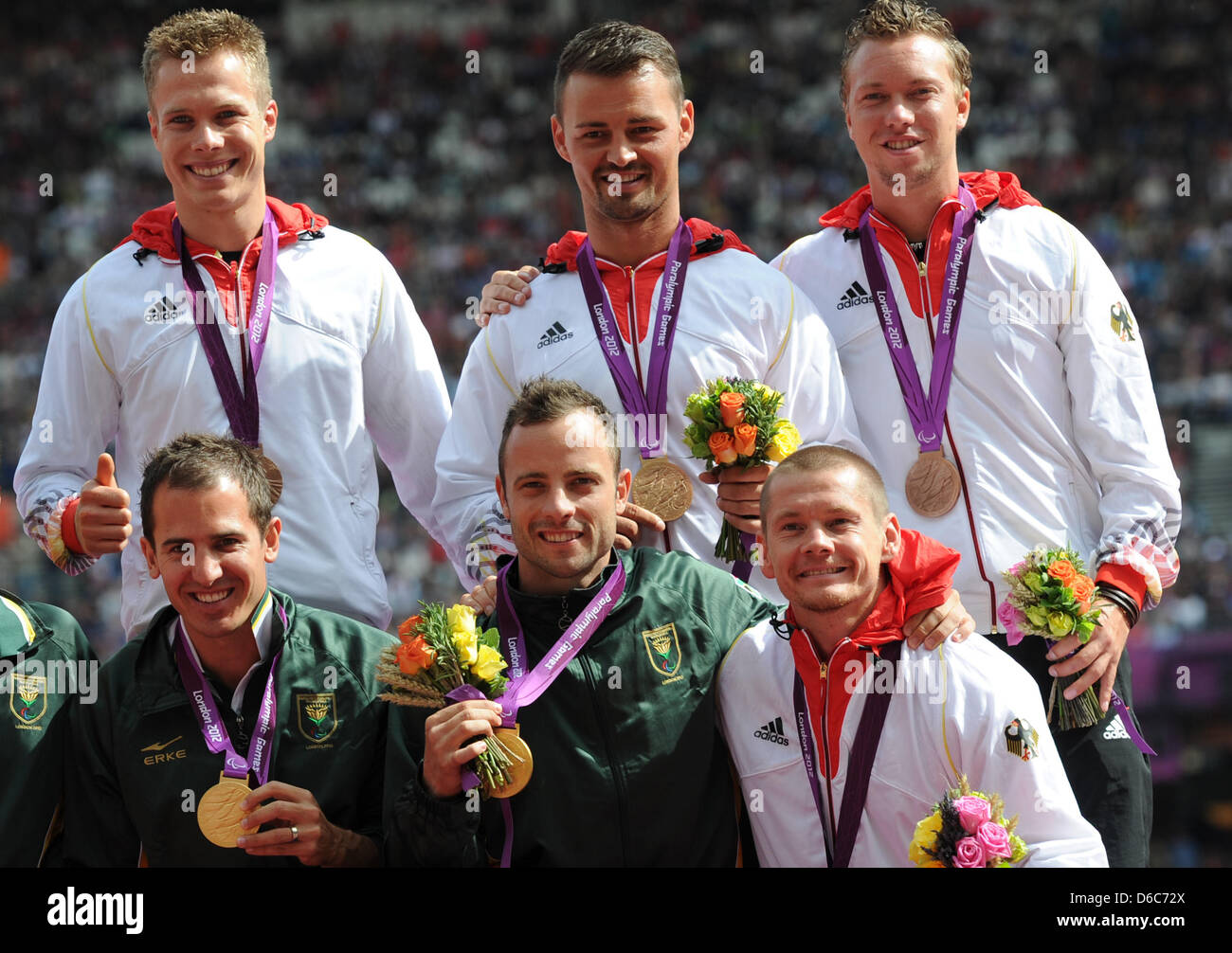 The German relay team Markus Rehm (l-r above), Heinrich Popow, David Behre and Wojtek Czyz are seen with their bronze medals and South Africans gold medalists Oscar Pistorius (C) and Arnu Fourie during the victory ceremony for men's 4x100m relay -T42-46 at the Olympic Stadium during the London 2012 Paralympic Games, London, Great Britain, 06 September 2012. Photo: Julian Stratensch Stock Photo