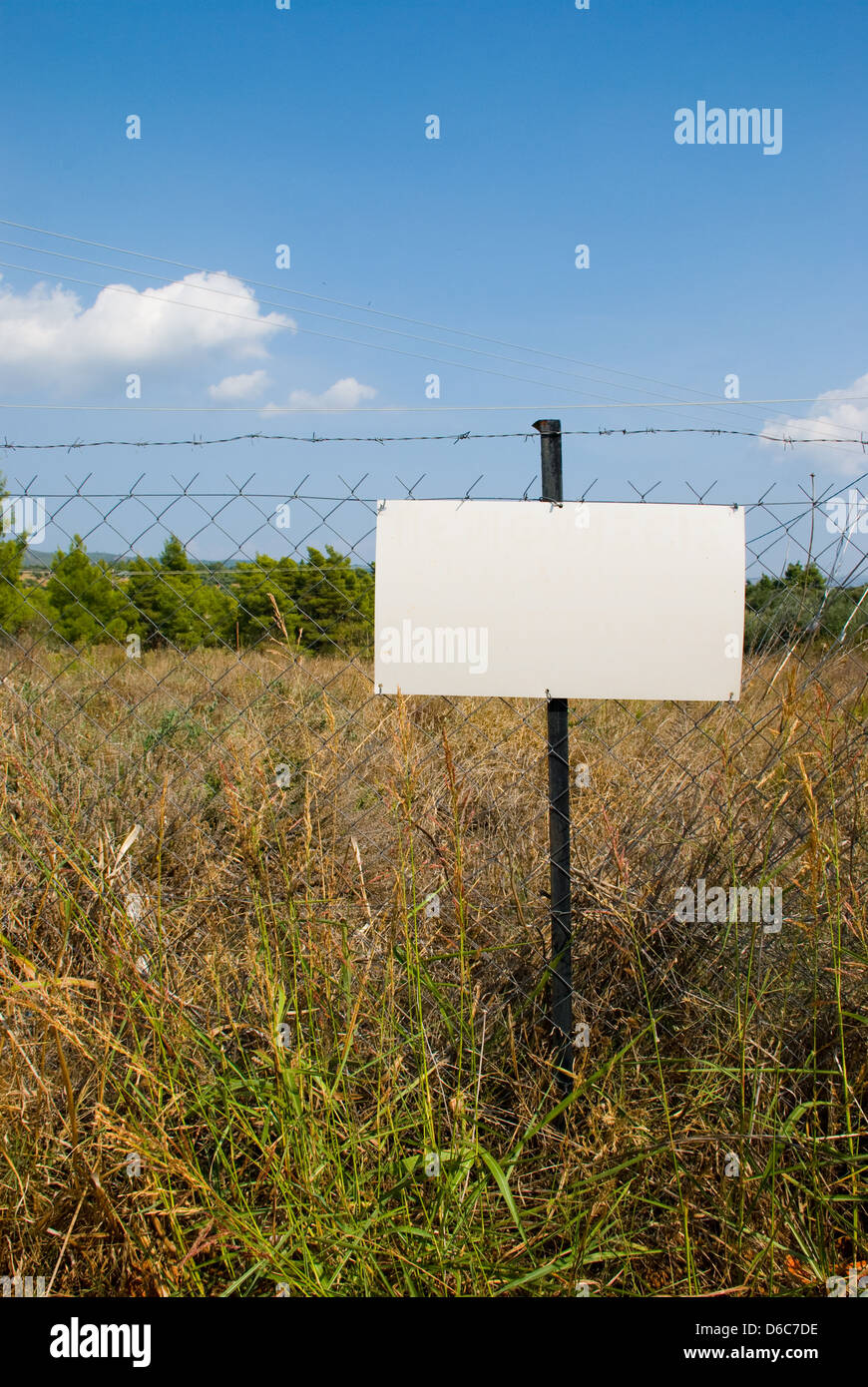 Blank white sign on a chain link fence. Stock Photo