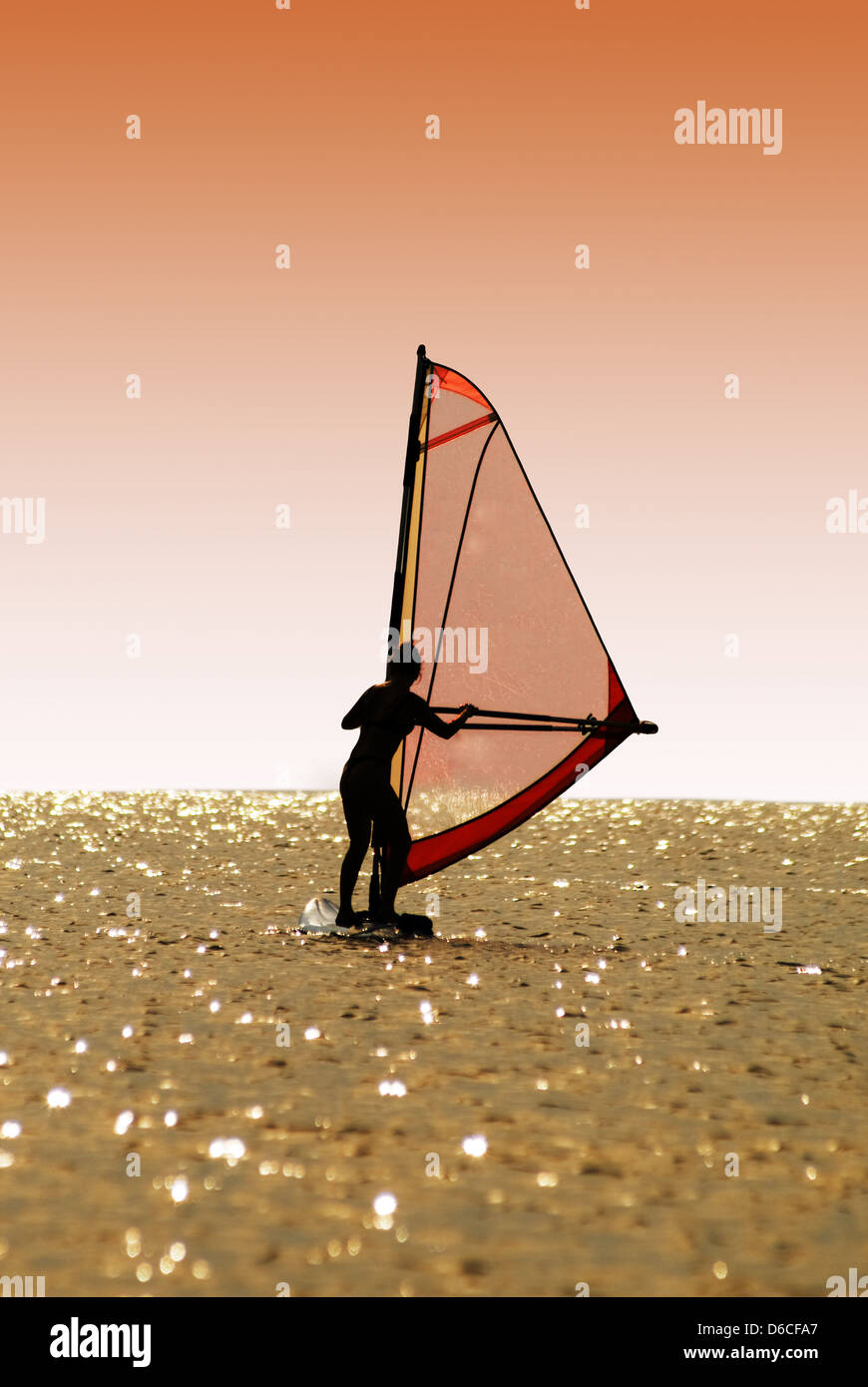 Silhouette a women on a windsurf on waves Stock Photo