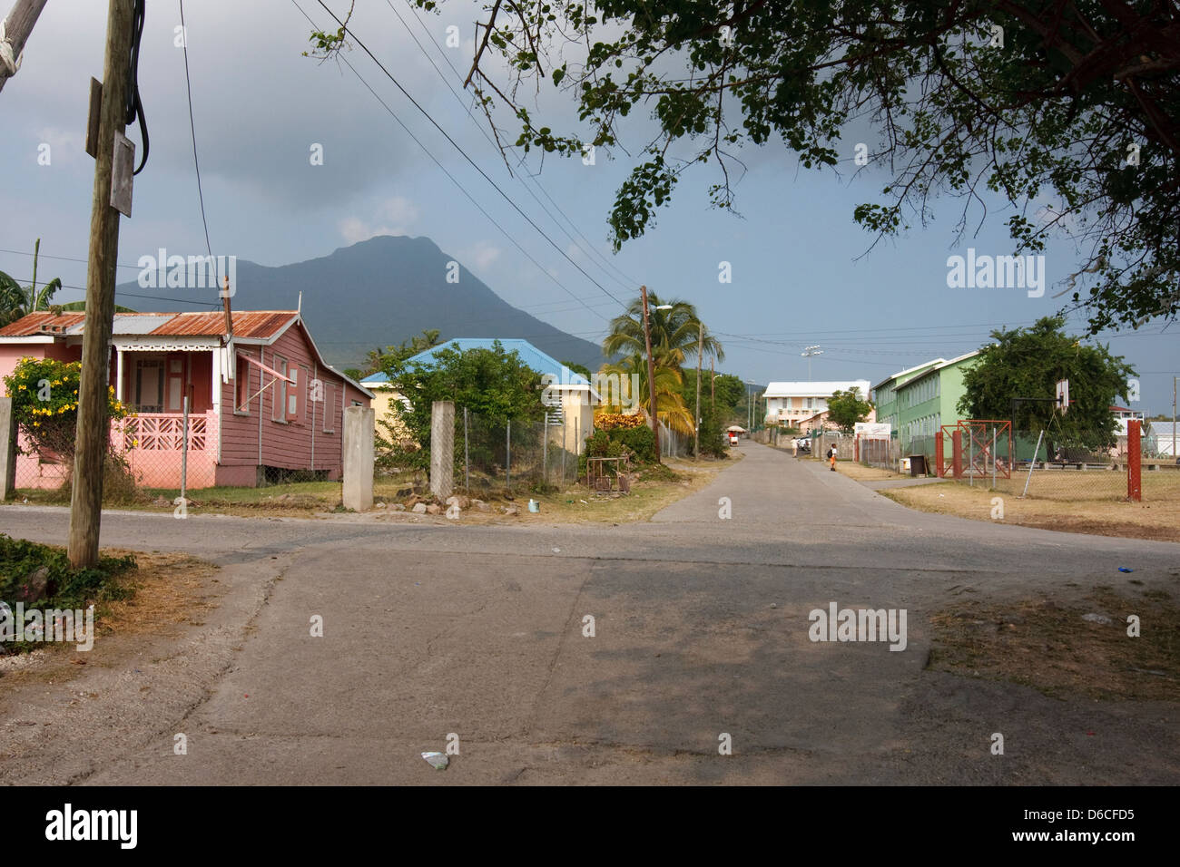 Nevis Peak rises in the distance beyond residential houses on the Caribbean island of Nevis Stock Photo