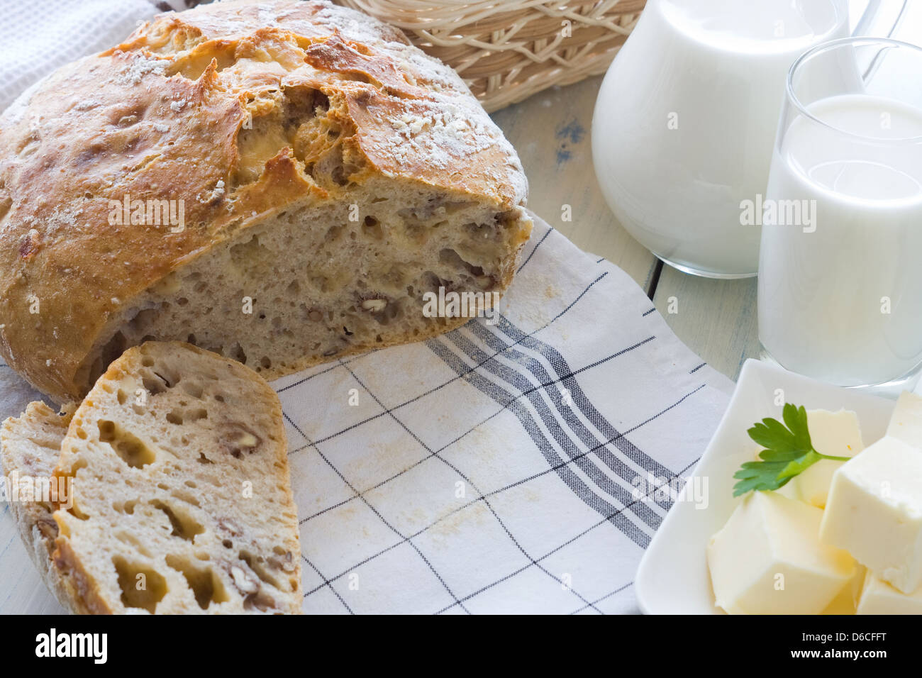 A freshly baked loaf of homemade bread with ripe cheese and walnuts Stock Photo