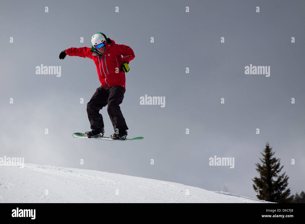 A snowboarder makes a jump at Red Mountain resort, Canada Stock Photo