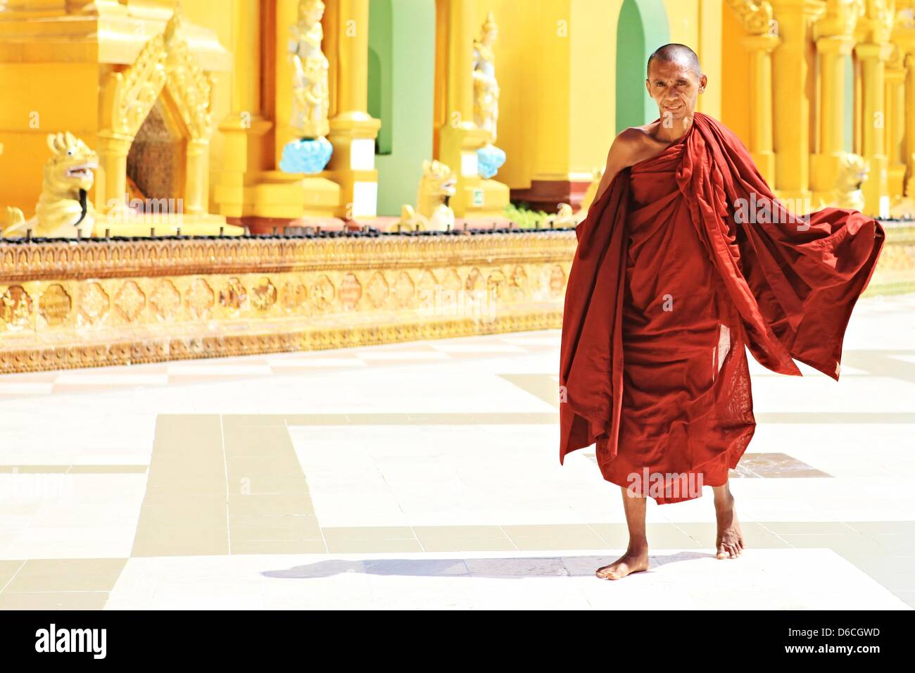 A monk in red walks at Shwedagon Pagoda in Yangon, Myanmar, 6 February 2013. Stock Photo