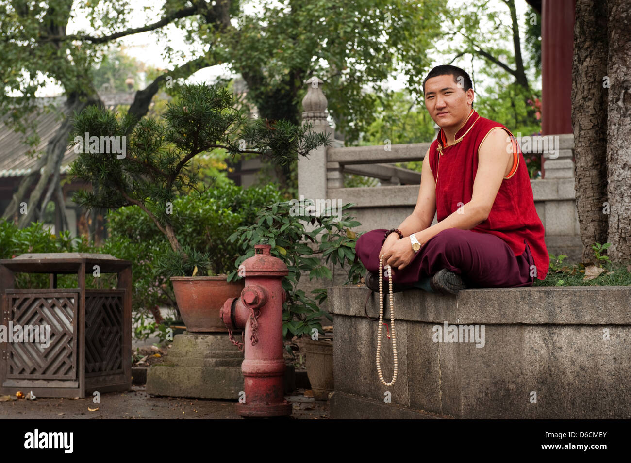 Guangzhou, China, a monk sitting under a tree in the courtyard of Filial Piety Temple Stock Photo