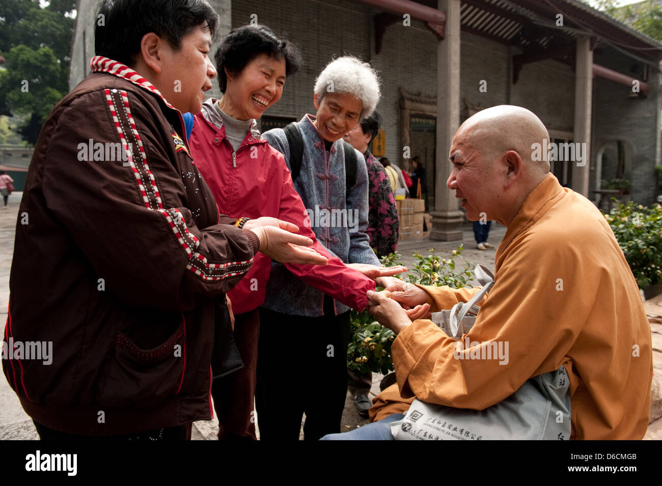 Guangzhou, China, is a monk acupressure with visitors in Filial Piety Temple Stock Photo