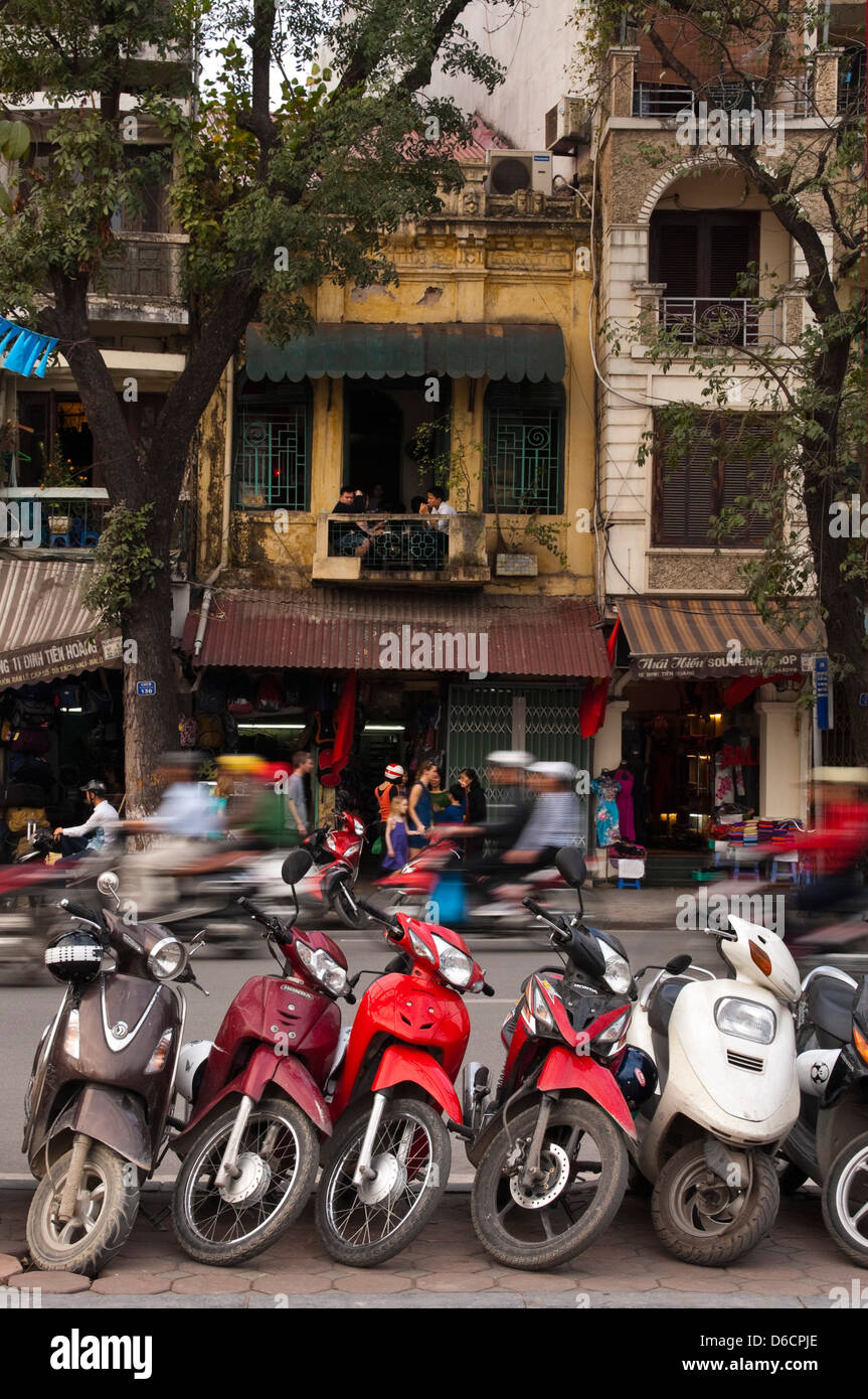 Vertical view of lots of mopeds, the favoured form of transport in Vietnam parked on the side of the road. Stock Photo
