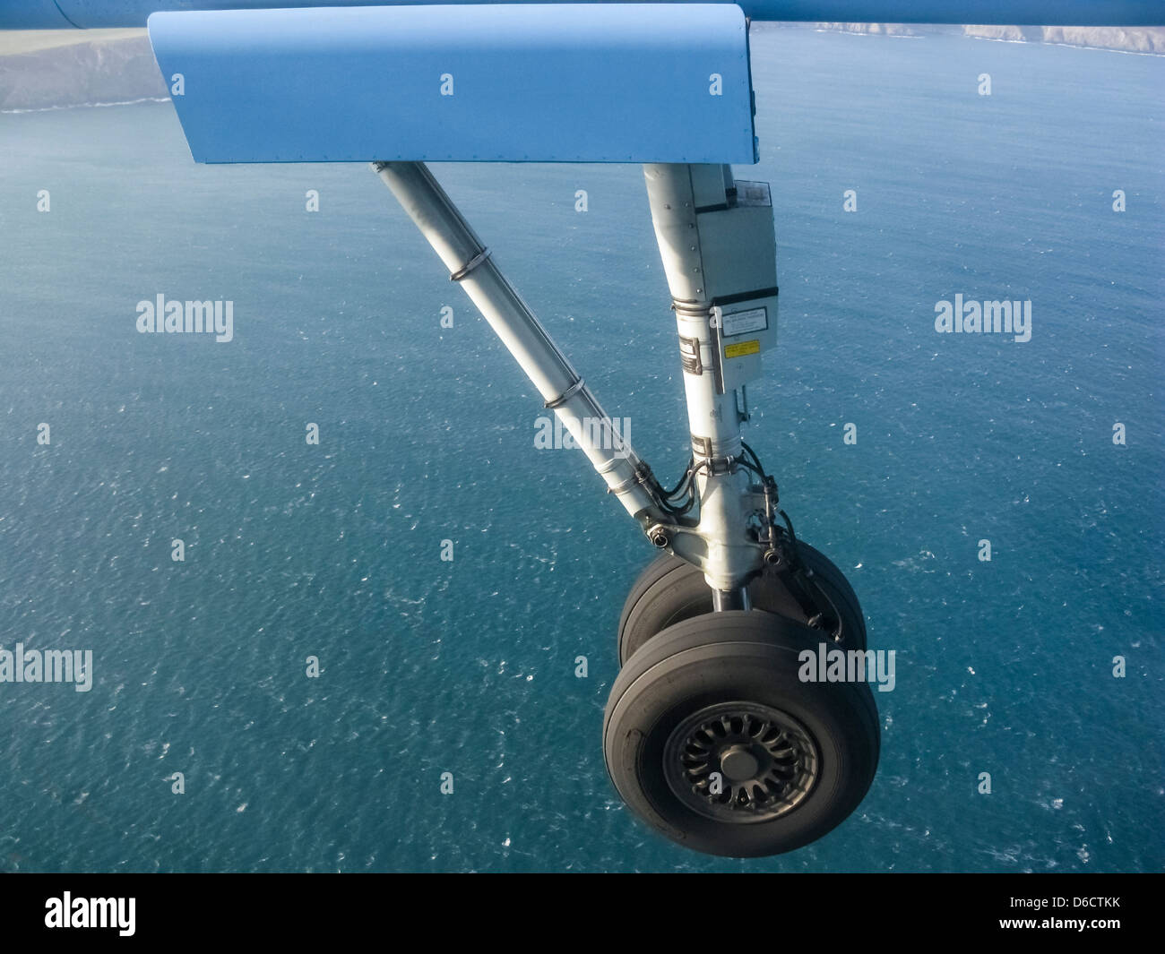 Landing gear of plane on its approach to landing,over the sea.It is a