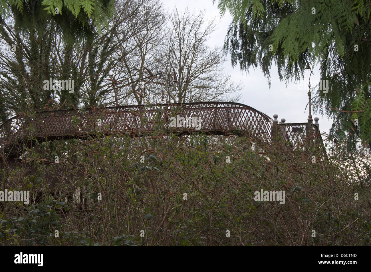 cast iron railway footbridge, disused,awaiting restoration, undergrowth Stock Photo