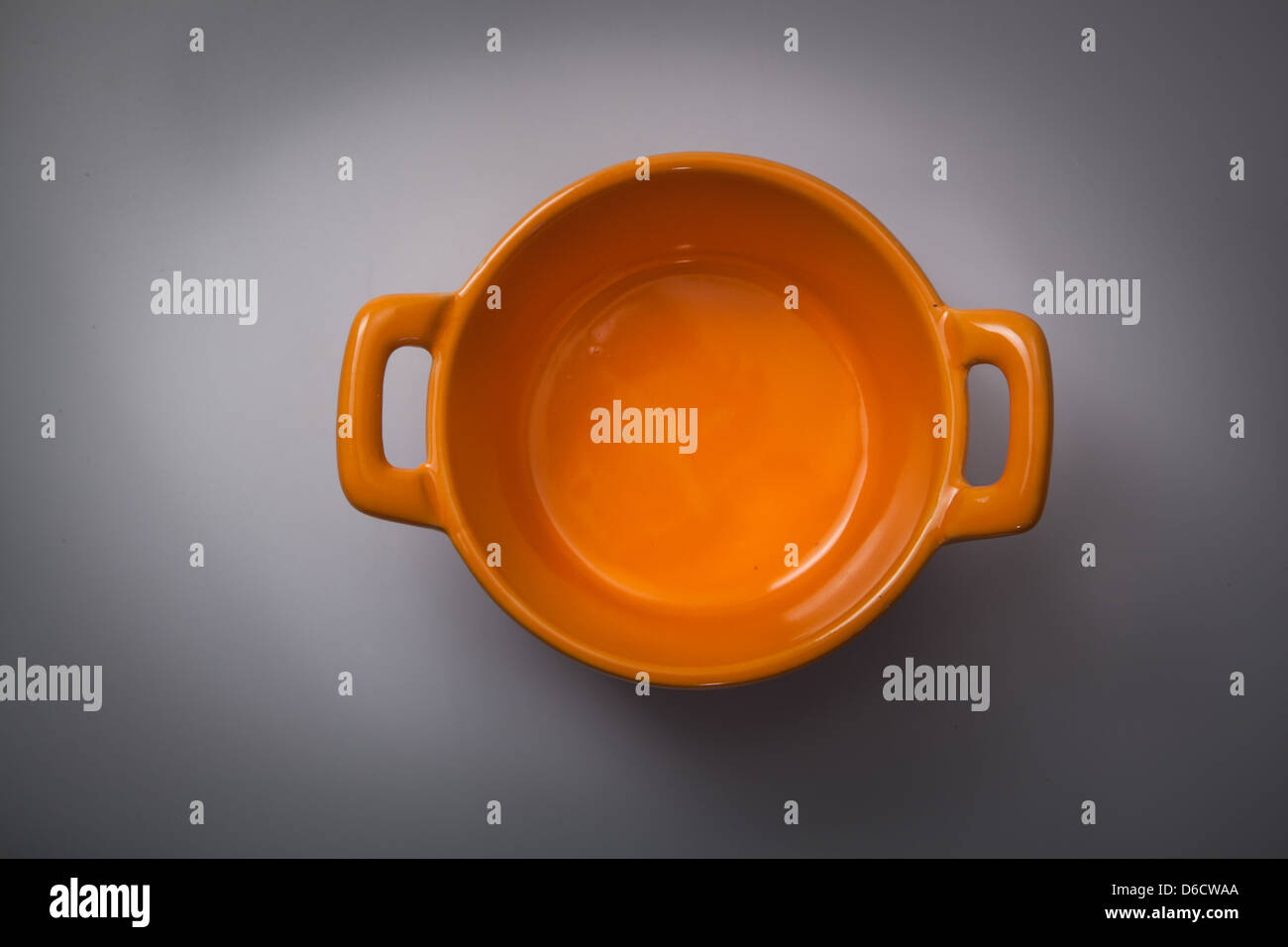 Orange cooking pot on a grey background Stock Photo Alamy