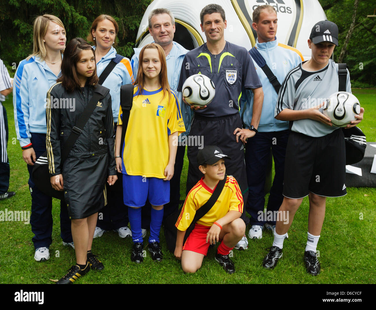 World Cup referee Markus Merk (GER) holds the official ball and stands with volunteers during a media session for journalists. Stock Photo