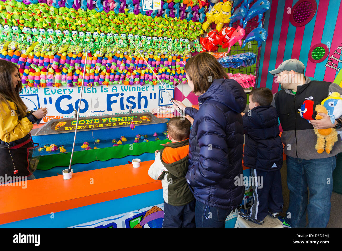 Family, young parent with two children, playing games on the boardwalk
