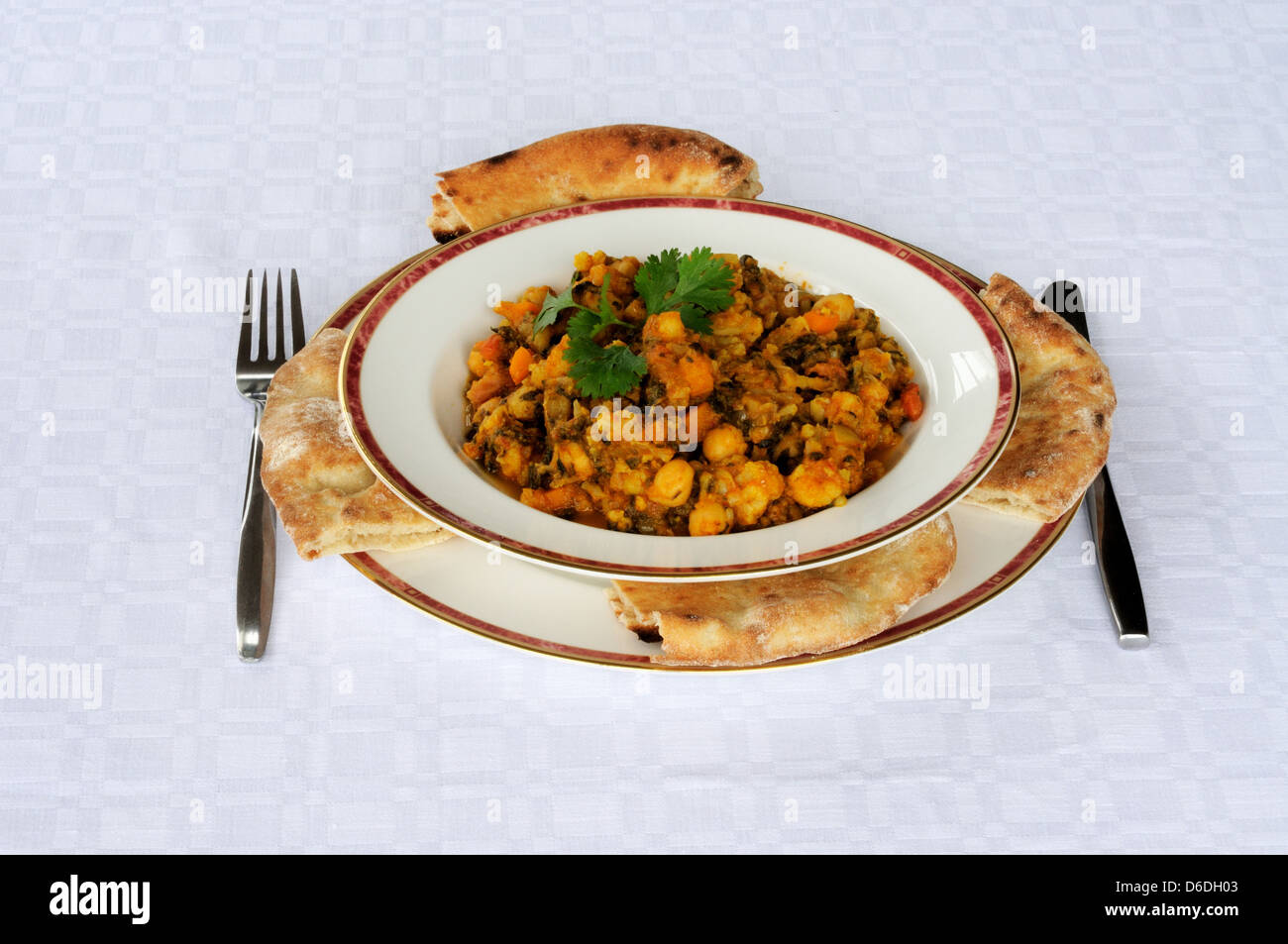 Chickpea and spinach balti with Naan bread on a white background Stock