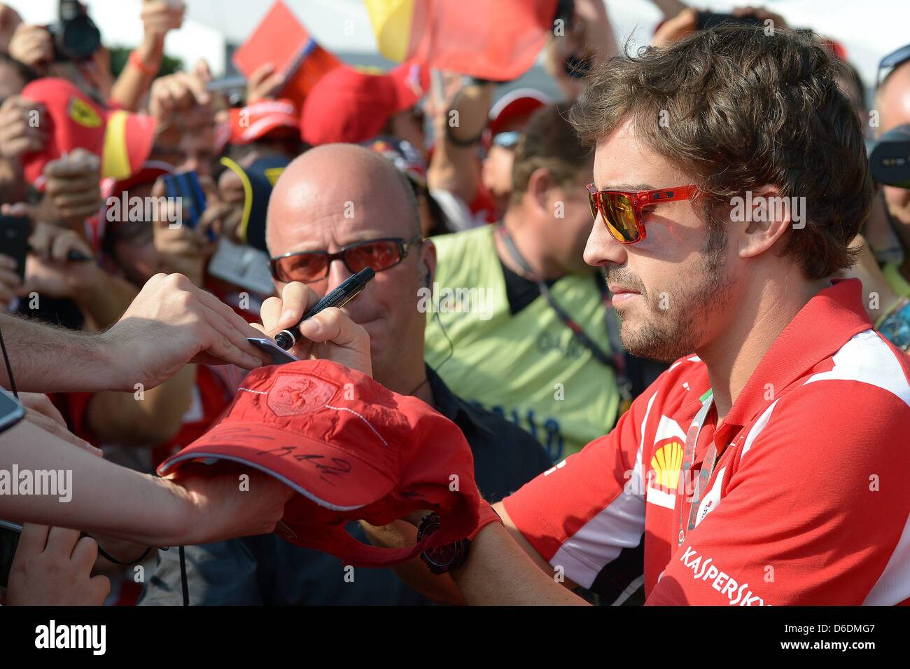 Spanish Formula One driver Fernando Alonso of Ferrari signs autographs ...