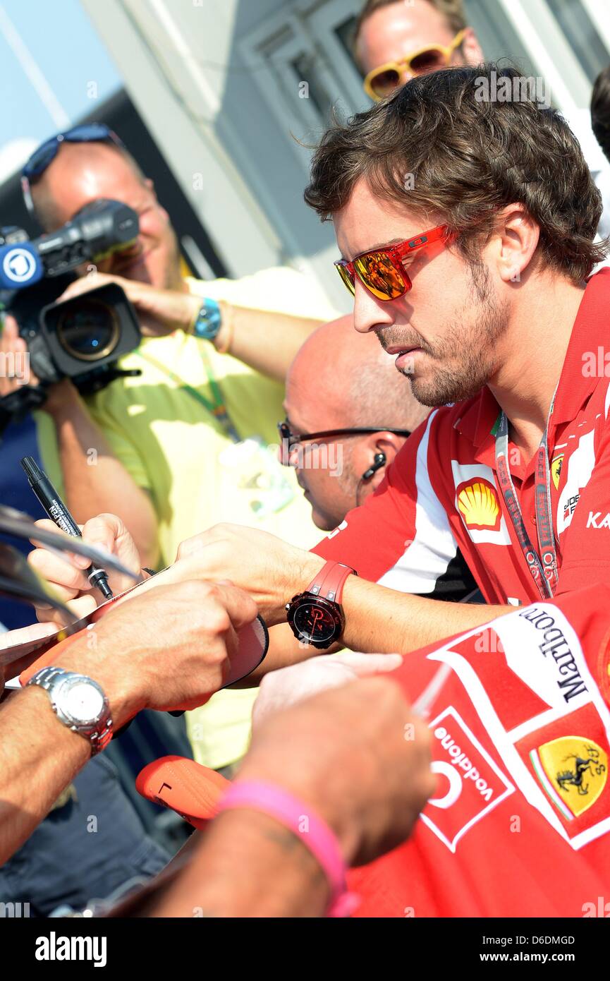 Spanish Formula One driver Fernando Alonso of Ferrari signs autographs ...