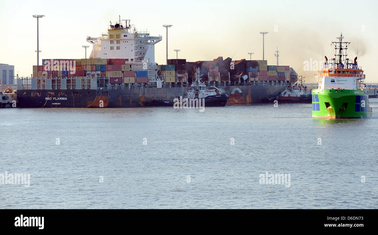 Heavily damaged container ship MSC 'Flaminia' lies at the JadeWeserPort in Wilhelmshaven, Germany, 09 September 2012. Seagoing tugboat 'Fairmount Explorer is pictured on the right. The ship caught fire on the Atlantic in June. The ship carrying some containers with dangerous load was then towed from the Sout-West coast of Great Brtiain to Wilhelmshaven. Photo: INGO WAGNER Stock Photo