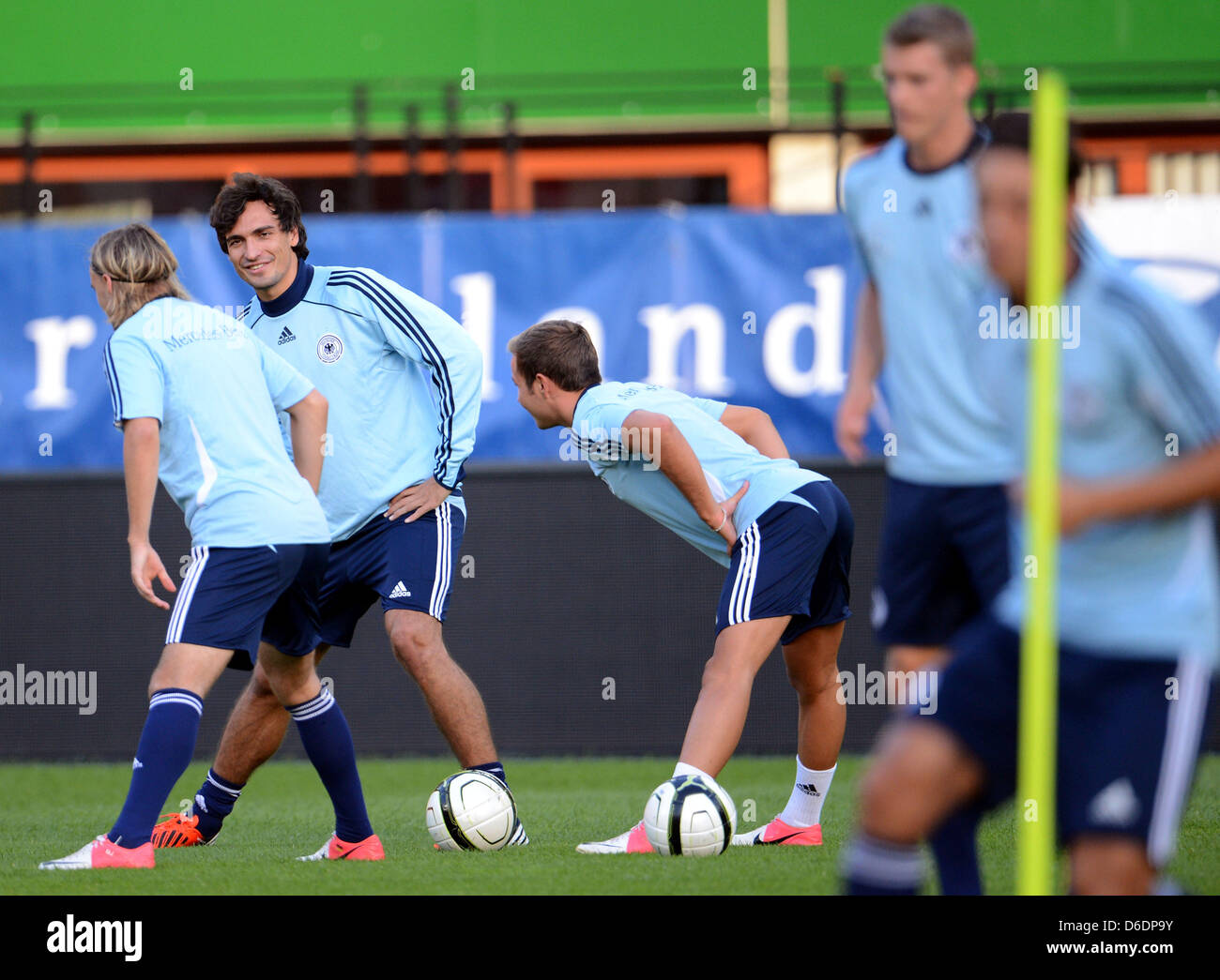 Germany's Marcel Schmelzer (L-3-R), Mats Hummels and Mario Goetze stretch and talk during a practice session of the national soccer team at Ernst Happel Stadium in Vienna, Austria, 10 September 2012. The German national soccer team prepares for its upcoming FIFA World Cup 2014 qualification match against Austria on 11 September. Photo: Peter Steffen Stock Photo