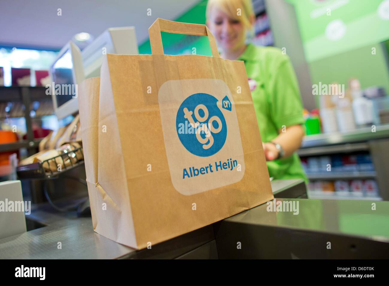 An employee packs a bag in an 'Albert Heijn to go' mini-market in Aachen, Germany, 12 September 2012. The Dutch retail group Ahold will open 10 of these stores in Germany within a year. Photo: ROLF VENNENBERND Stock Photo