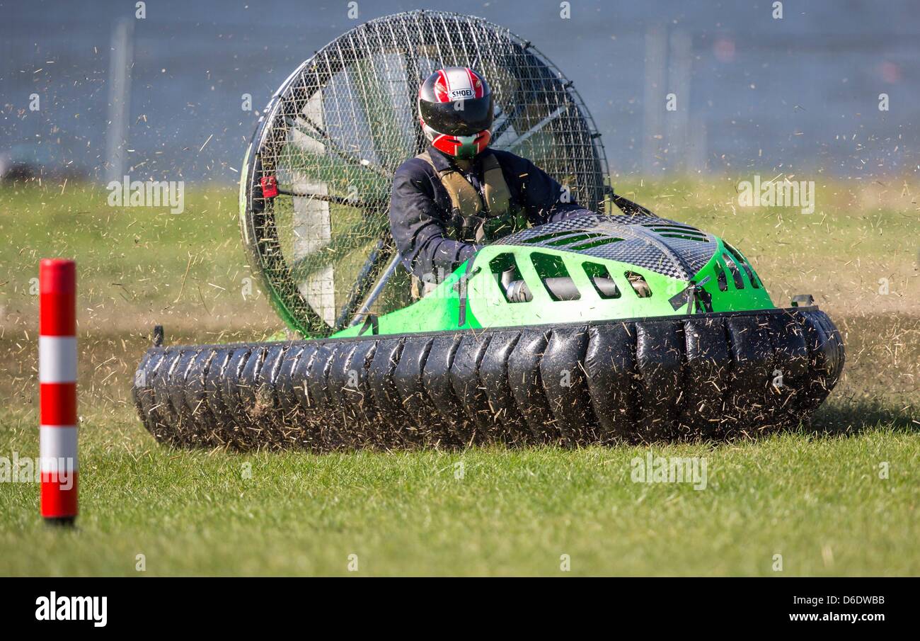 A hovercraft driver speeds along the race course at the ...