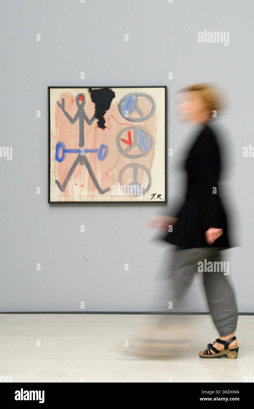 A woman walks past artwork by A.R. Penck at Kunsthalle im Lipsiusbau in