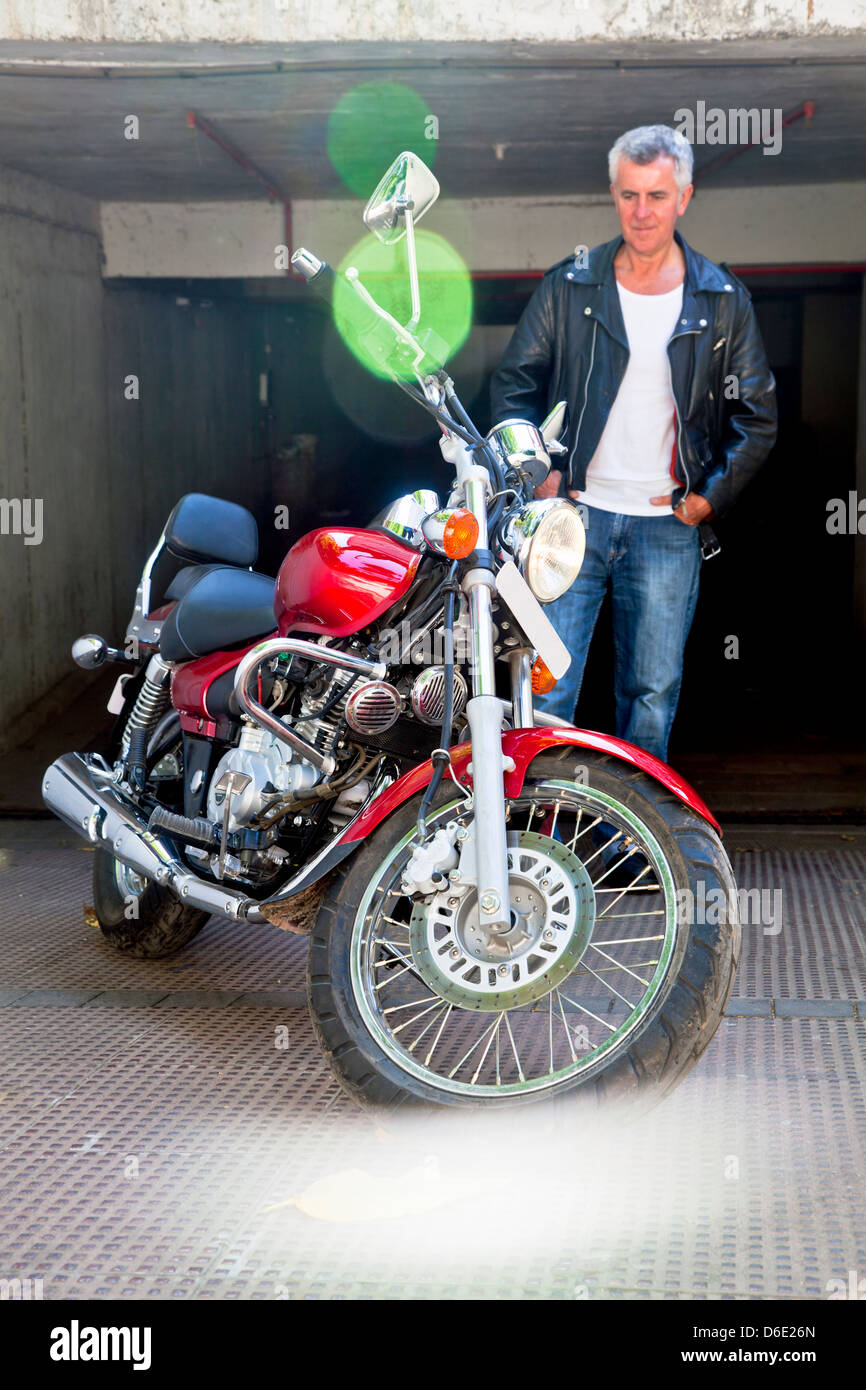 Red cruiser motorcycle and its doting admirer. Caucasian model and generic photograph was taken in Bombay India Stock Photo